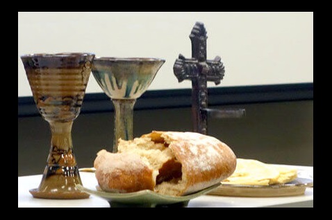 Communion table with chalices, broken bread, and a cross. Image courtesy Connectional Table.