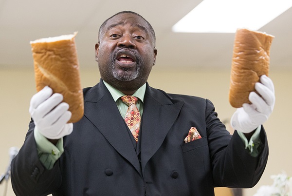 2333_4421_203llpwindley008_20746592368_o-w The Rev. Mark Windley blesses communion bread at Amazing Grace Community of Faith in Louisville, Kentucky. Photo by Mike DuBose, United Methodist Communications.