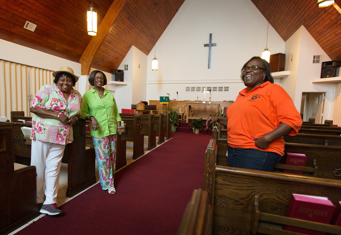Church members (from left) Burnetta D. Fauria, Angelique White-Williams and Andrea Sanchez-Reese show the restored sanctuary at Hartzell United Methodist Church in New Orleans' Lower 9th Ward. Among the items dedicated last year were new imprinted hymnals from Cokesbury Cares. Photo by Mike DuBose, UMNS. 