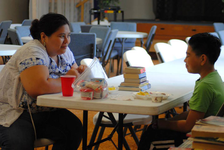 Adrian Perez and her son, Jonathan, enjoy an afternoon that includes a free lunch in the Havelock Cafe, picking up books for summer reading and selecting snacks and breakfast foods for the week. Photo courtesy of Delaney Fischer.
