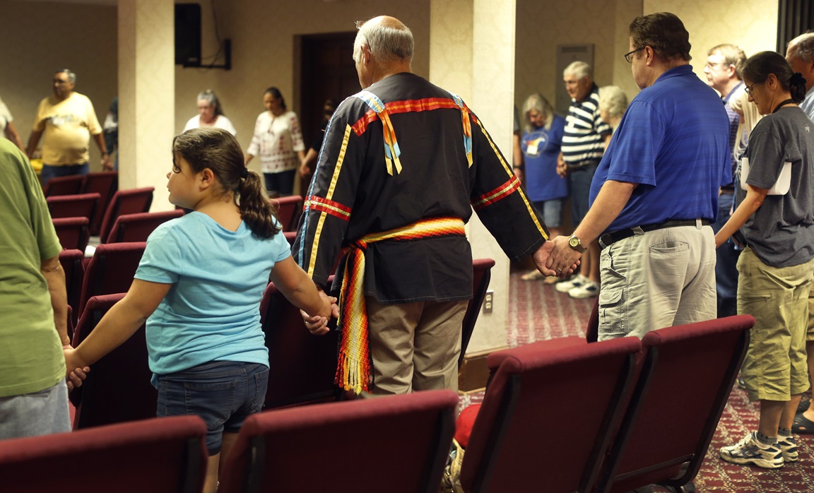Attendees of the Native American Summer Conference form a circle in prayer. Photo by Kathleen Barry, United Methodist Communications