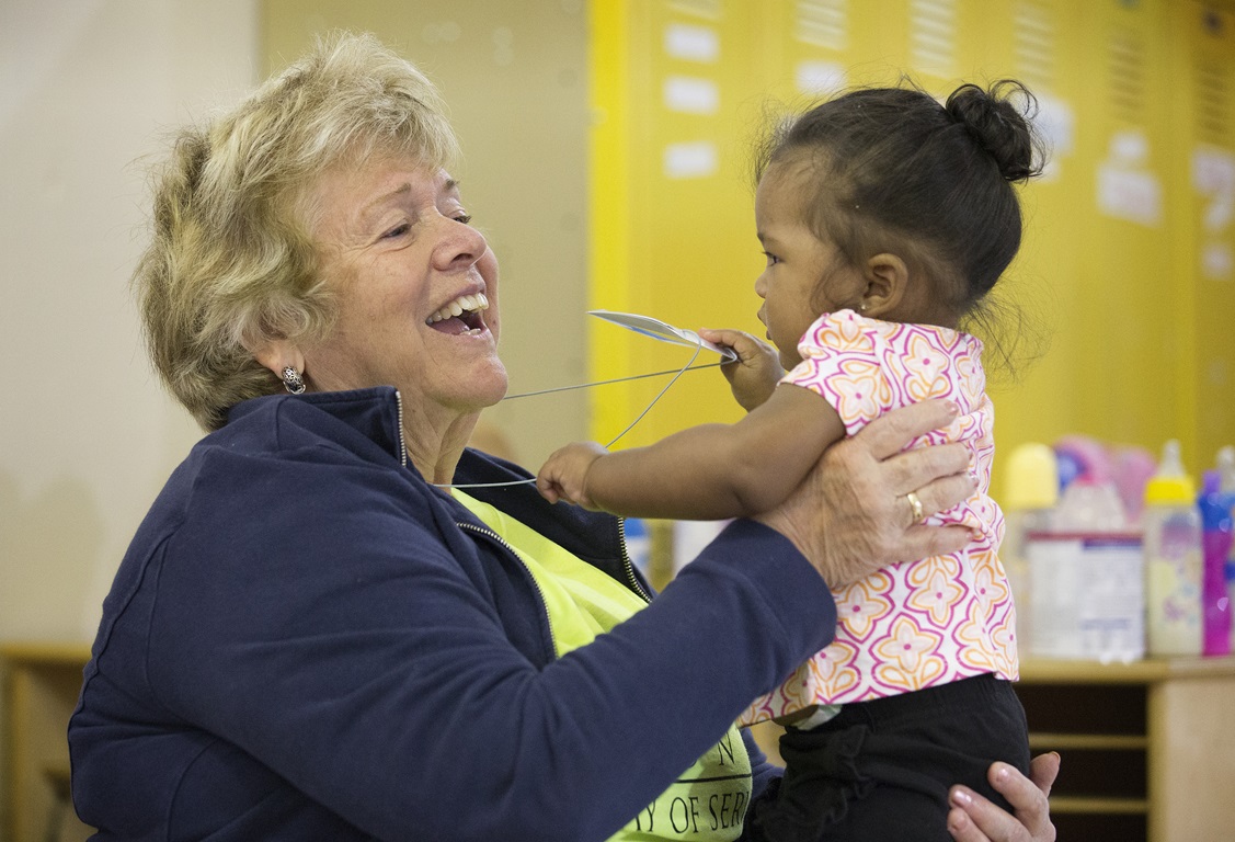 A volunteer plays with a young girl at the St. Benedict Center for Early Childhood Education in Louisville, Ky.