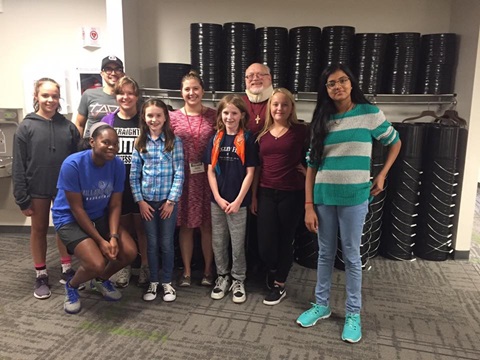 Students from Faith Westwood UMC IMPACT afterschool program for middle schoolers in Nebraska have just finished unloading 500 buckets and lids donated to the church. Behind them are just a small number of those buckets. PHOTO: VIKKI O’HARA
