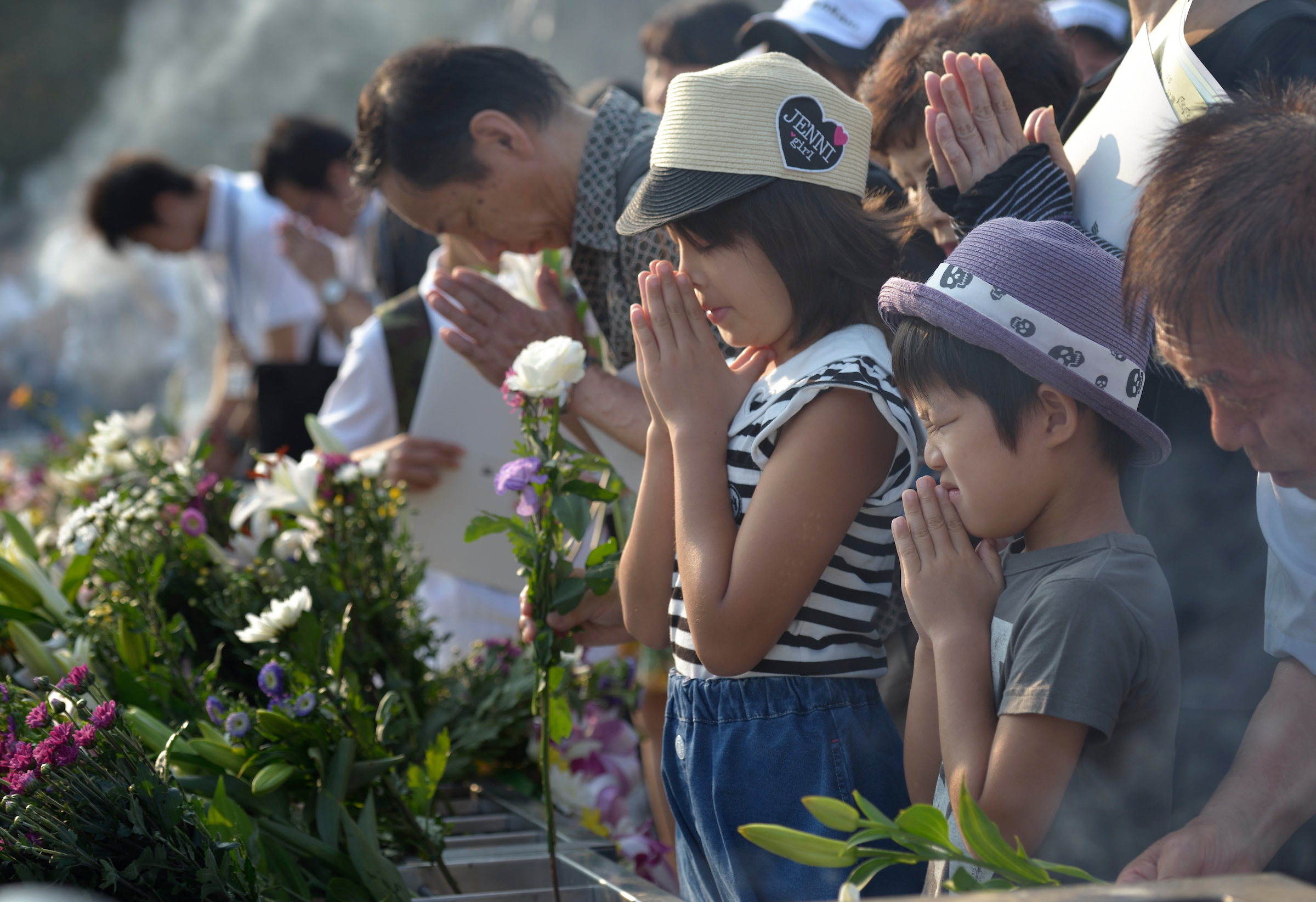 People praying on August 6, 2015, at a memorial in Hiroshima, Japan, that commemorates the victims of the atomic bombing of the city by the United States in 1945. PHOTO: PAUL JEFFREY