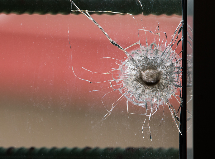 A bullet hole in a newsroom window at The Voice of Hope serves as a reminder of election-related violence in 2011. The station remained on the air during the crisis and several staffers took shelter there.