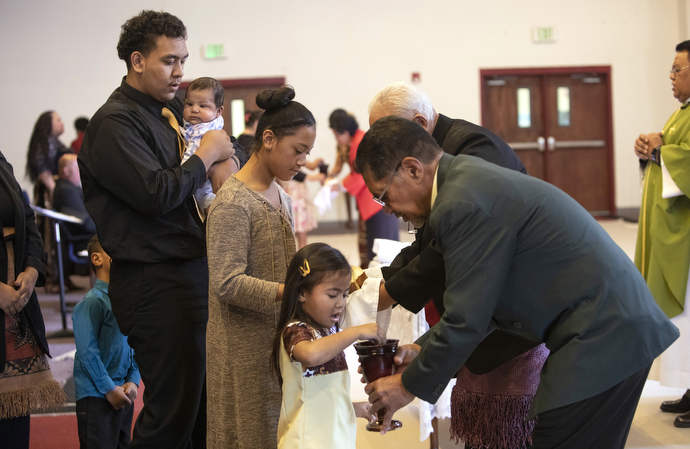 Sekope Fainu (left) and other Tongan youth receive Communion.