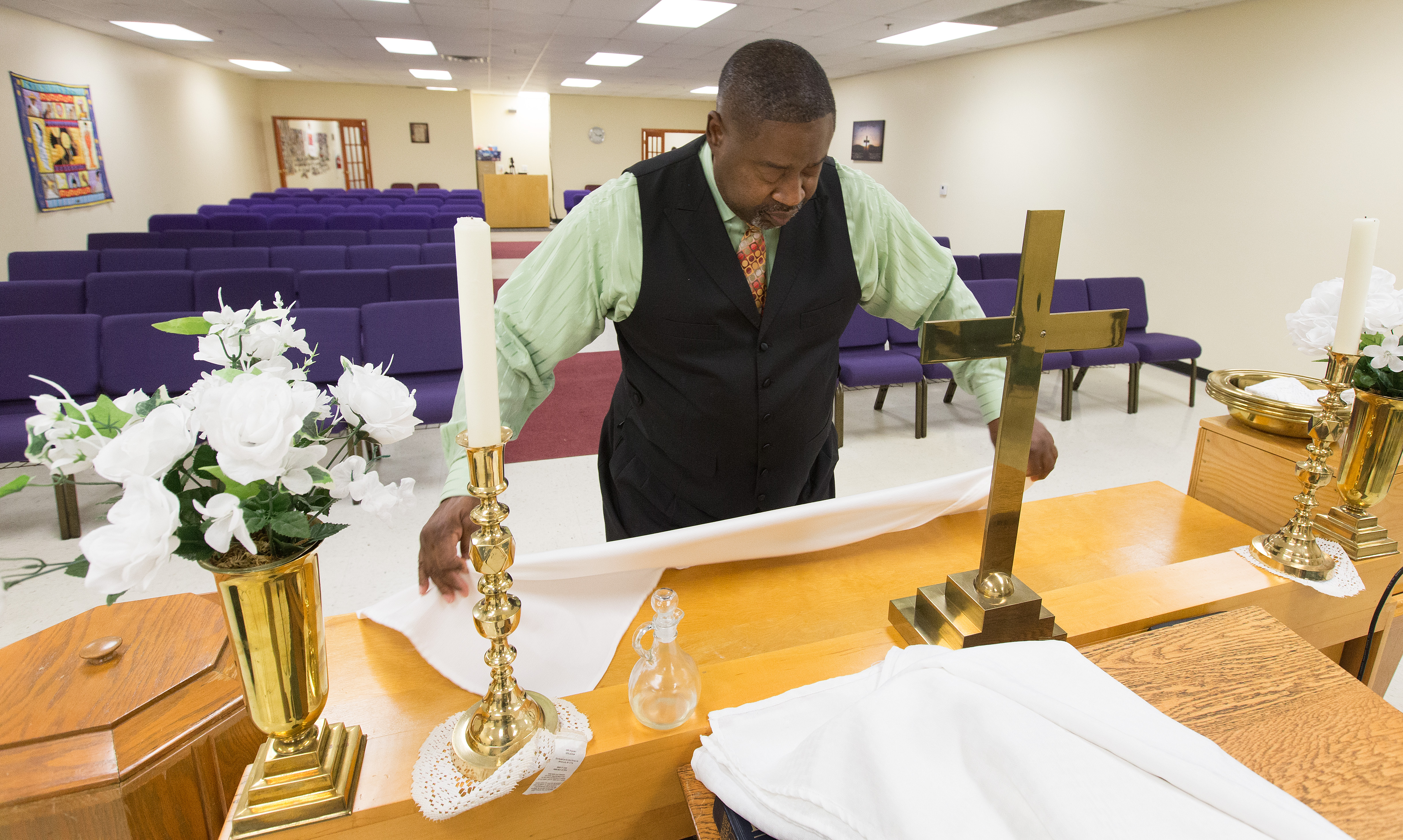 The Rev. Mark Windley prepares the altar for worship at Amazing Grace Community of Faith in Louisville, Ky. Photo by Mike DuBose, UMNS.