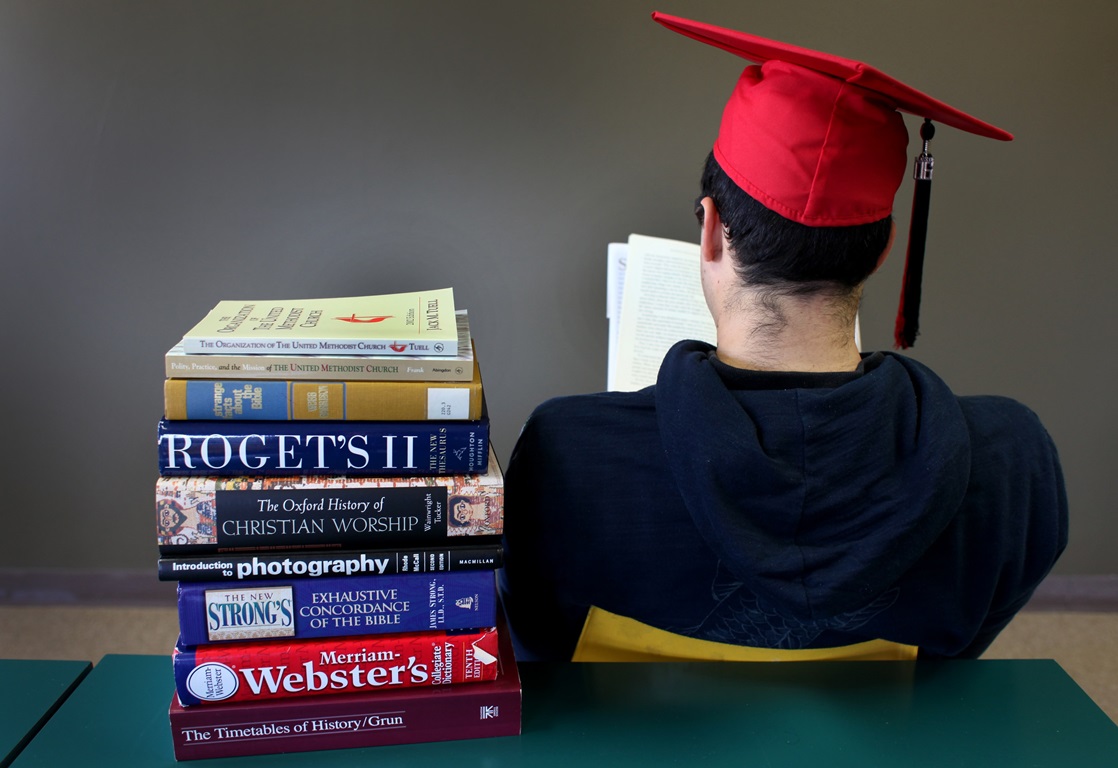 A student with books. Photo illustration by Kathleen Barry, United Methodist Communications. 