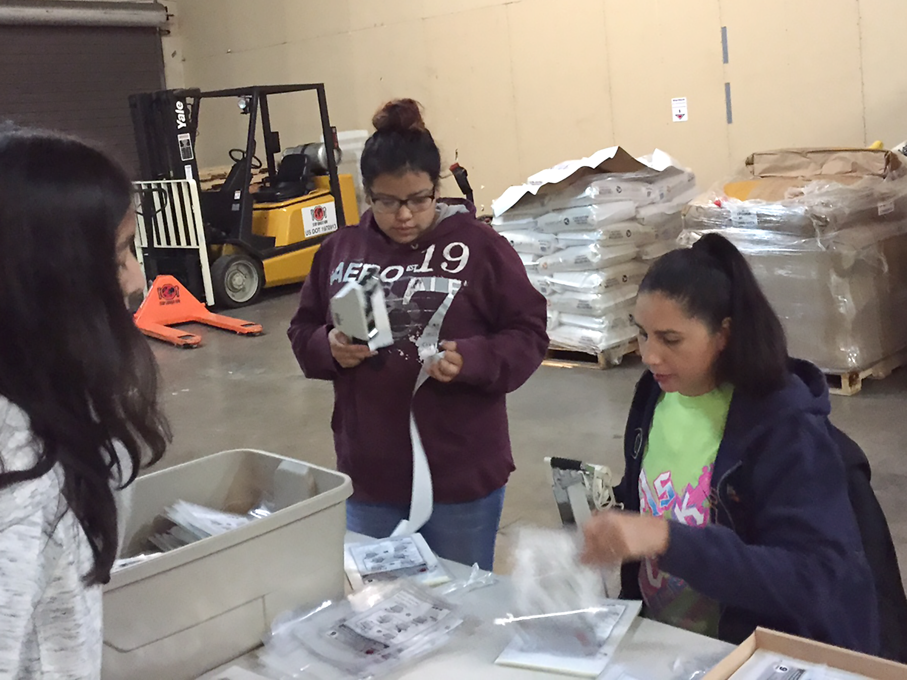 Lynnetta Eyachabbe assists teen girls as they pack meals during a project to fight hunger. Photo courtesy of Jason and Lynnetta Eyacchabe.