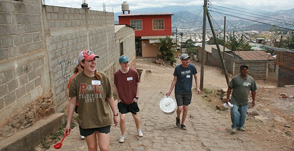 student missionaries carrying bucket