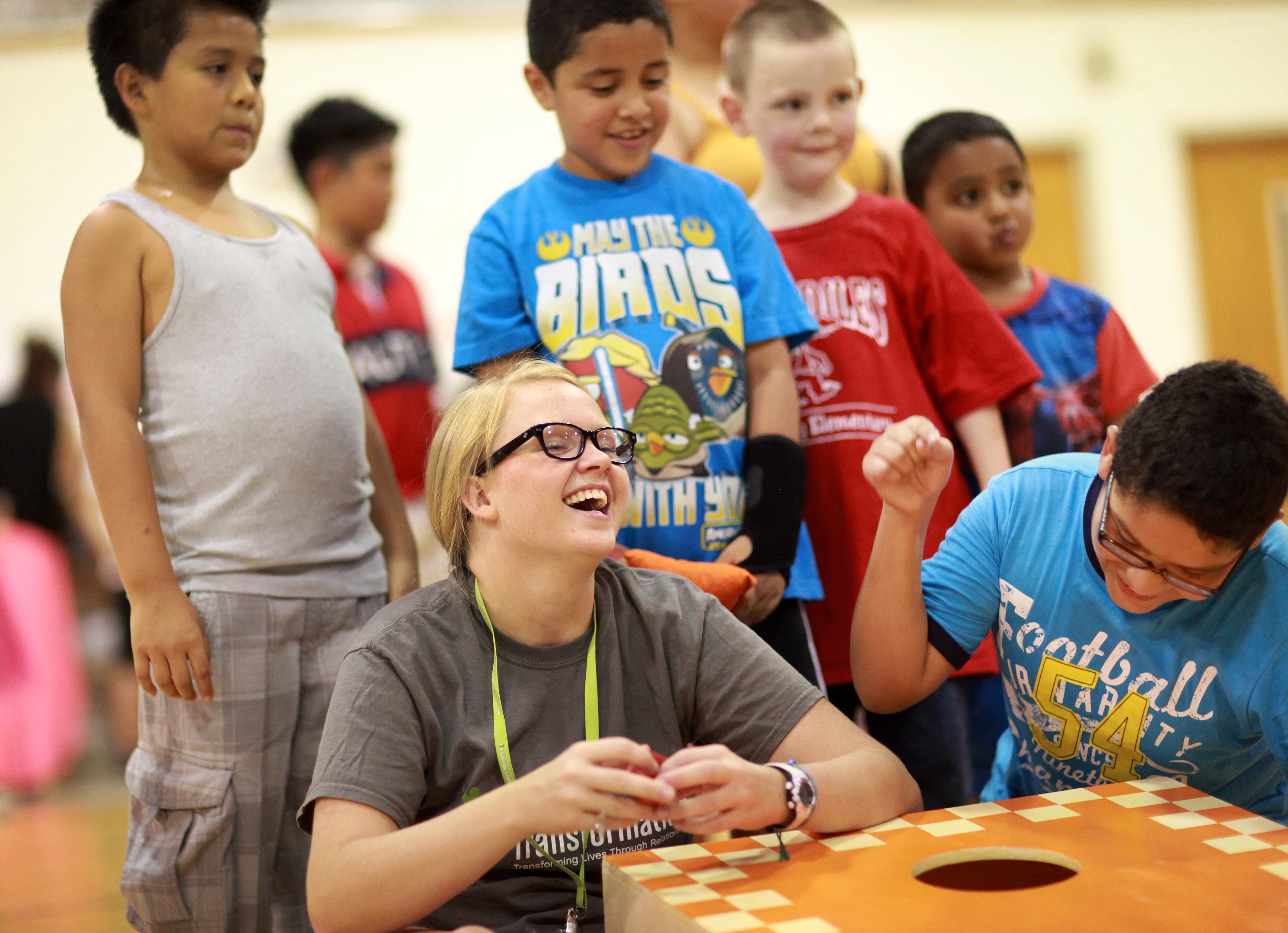  Challye Hays laughs with children as they play corn hole in the gym during the Project Transformation Family Fun Night at Antioch United Methodist Church. Photo by Kathleen Barry, United Methodist Communications. This event took place July 24, 2014 at the Antioch United Methodist Church. Photo by Kathleen Barry, United Methodist Communications. 
