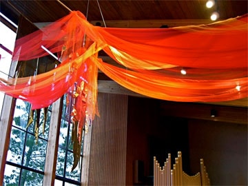Using red fabric draped above the congregation can create a dramatic symbol of Pentecost in worship. 