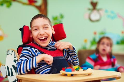 Cheerful boy with disability at rehabilitation center for kids with special needs. Photo by olesiabilkei, iStockPhotos.com.