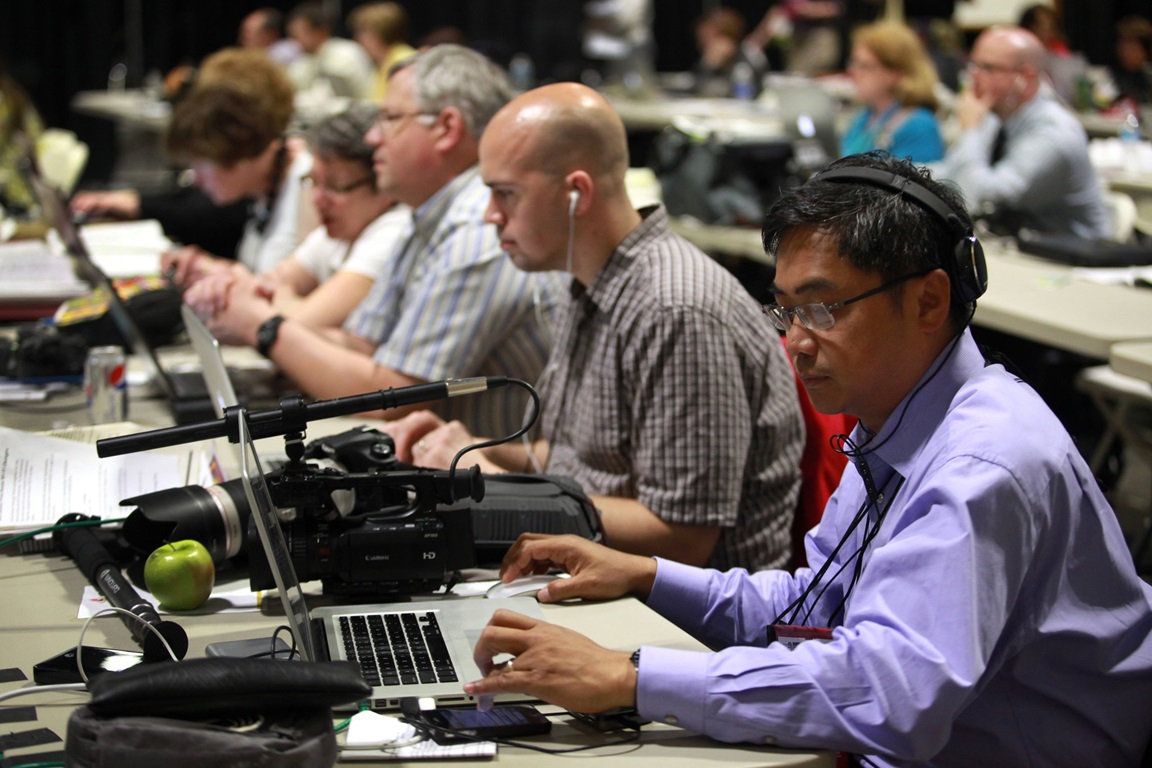 (From right) David Valera, Patrick Scriven, Greg Nelson, the Rev. Karen Nelson and Linda Rhodes work in the newsroom at the 2012 United Methodist General Conference in Tampa, Fla. A UMNS photo by Kathleen Barry.