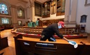Custodian James Jimmerson disinfects pews to prevent any possible spread of the coronavirus at Belmont United Methodist Church in Nashville, Tenn., on Sunday, May 10, 2020, following online worship, which is recorded in the sanctuary. Photo by Mike DuBose, UMNews