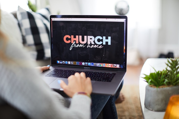 Une femme assiste à un service religieux depuis son domicile. Image par Prixel Creative, Lightstock.com.