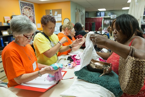Anita Watkins (right) shops for clothing and household items at the Free Store at United Methodist Church for All People in Columbus, Ohio, as part of the Ubuntu Day of Service during the United Methodist Women Assembly 2018 in Columbus, Ohio. Helping her are Becky Kegnans (left), a United Methodist Woman from the North Texas Conference, and Kathy Wallace, who works at the Free Store. Photo by Mike DuBose, UMNS.