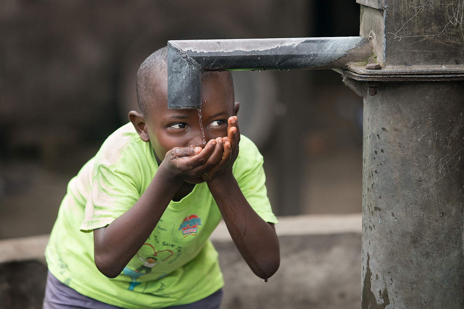 Joseph Ekow, 5, catches the final trickle of water after filling his bucket at a well behind John Kofi Asmah United Methodist Church in the West Point neighborhood in Monrovia, Liberia. Many families in this dense, urban area lack access to piped water. Photo by Mike DuBose, UM News