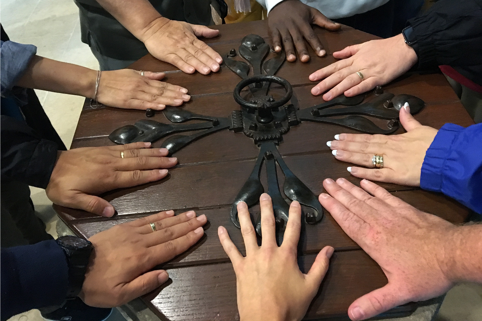 Members of the 2016 Wesley Pilgrimage in England rest their hands on the baptismal font at St. Andrew's church in Epworth where John Wesley was baptized. Photo by the Rev. Anita Mays.
