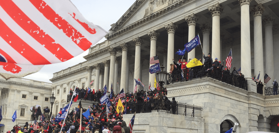 A crowd pressing up the steps towards the Senate Chamber of the Capitol. Photo by Tyler Merbler at Flickr. 2021.