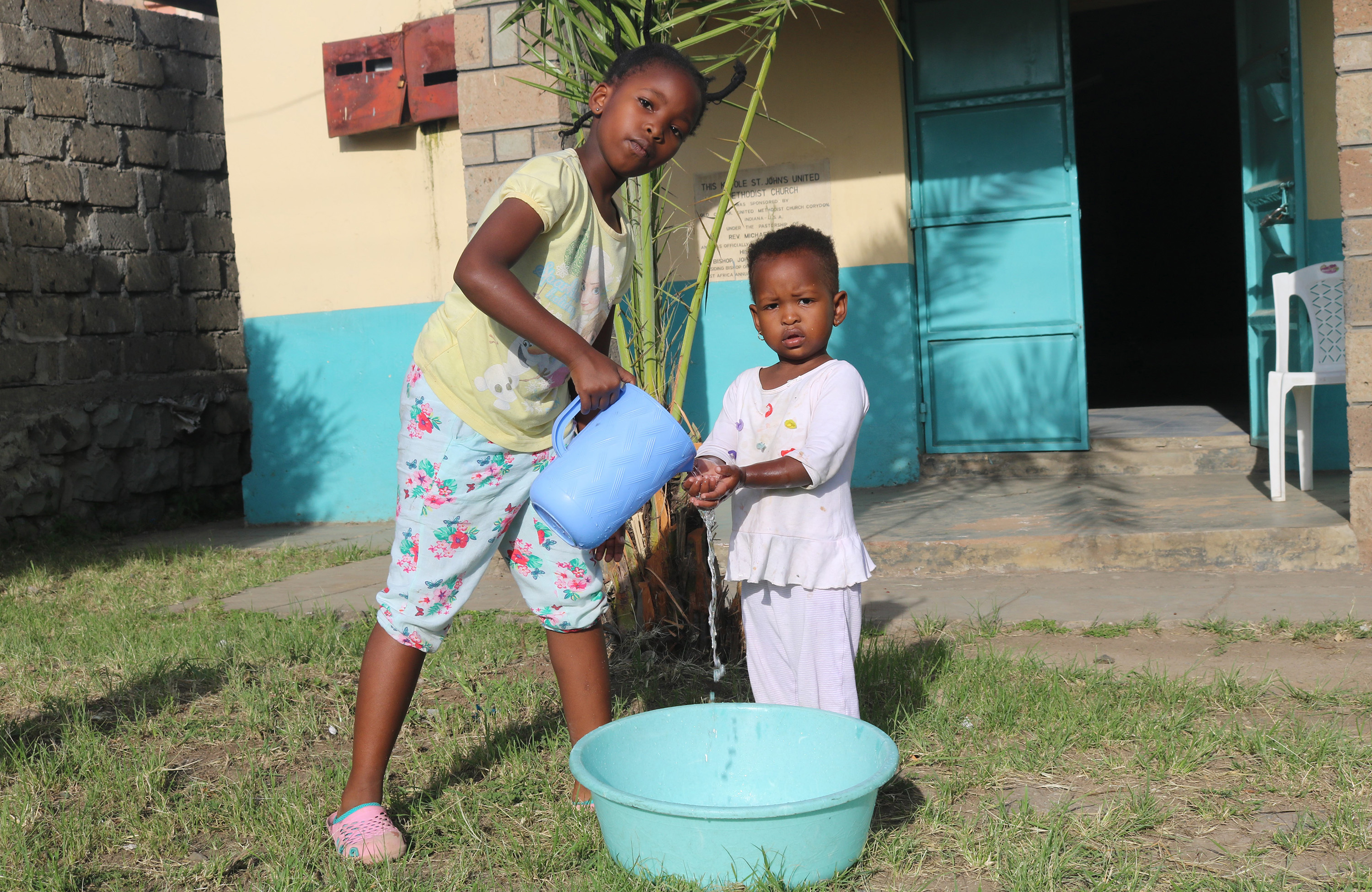 Nine-year-old Shantel Resse washes the hands of her younger sister, Reina Muthoni, at Kayole St. John’s United Methodist Church in Nairobi, Kenya. Churches in Kenya are urging members to wash their hands using soap or hand sanitizer to stop the spread of the coronavirus. Photo by Gad Maiga, UM News.  