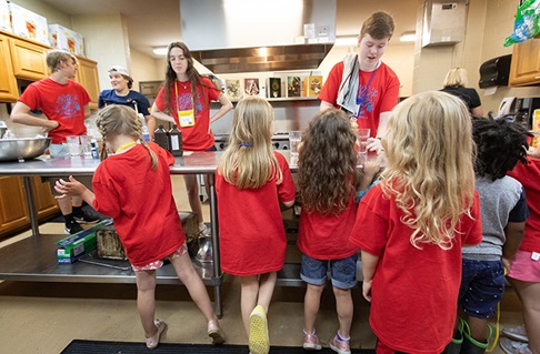 Ben Frey (right, rear) conducts a science experiment for children during vacation Bible school at Connell Memorial United Methodist Church. Photo by Mike DuBose, UM News.