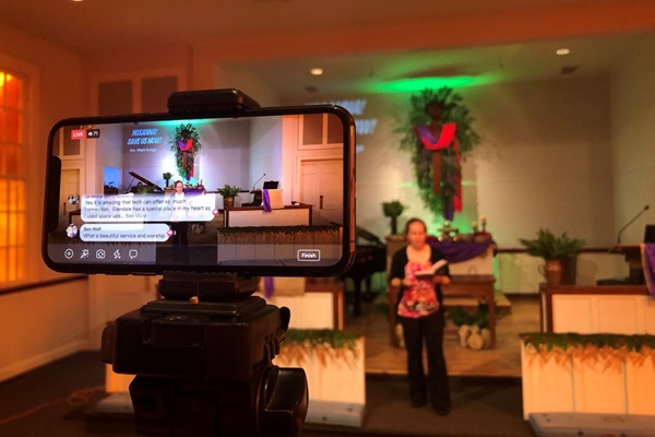 An iPhone streams the online worship service on Facebook Live at Glendale United Methodist Church in Nashville, Tenn. Due to the 2020 coronavirus pandemic, many churches are turning to online streaming to share worship. On the altar is the Rev. Stephanie Dodge, lead pastor. Photo by Steven Adair, United Methodist Communications.