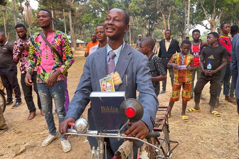 The Rev. Ngongo Asaka smiles after receiving a new bicycle and a Bible as tools for evangelism in Tunda, Congo. Asaka was among 52 pastors of rural United Methodist churches in the area who received the gifts from Crosspoint, a United Methodist church in Niceville, Fla. Photo by Chadrack Londe, UM News.