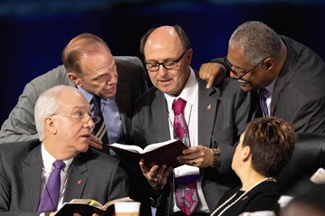 Bishops confer over the issue of whether the legislative committee can refer items to the denomination's Judicial Council for review during the 2019 United Methodist General Conference in St. Louis. Clockwise from lower left are Bishops Thomas Bickerton, John Schol, David Bard, Julius C. Trimble and Cynthia Fierro Harvey. Photo by Mike DuBose, UMNS.