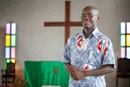 Isaac Broune accueille les visiteurs de l'Église Méthodiste Unie Jubilee à Abidjan, en Côte d'Ivoire, en 2008, avec son sourire et son hospitalité caractéristique. Isaac Broune est décédé le 5 mai à Abidjan. Il avait 48 ans. Photo de Mike DuBose, UM News.