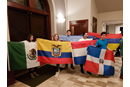 Children proudly hold flags that represent their national heritage during a worship service.