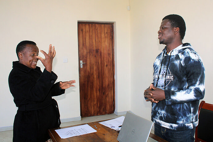“Pastor Collins” Kwasi Prempeh (right) communicates with Spiwe Mhere, a sign-language interpreter at The United Methodist Church’s main office in Mutare, Zimbabwe, in May. Prempeh aims to foster inclusive worship, where sign language is used and celebrated, especially in children’s ministry. Photo by Kudzai Chingwe, UM News.