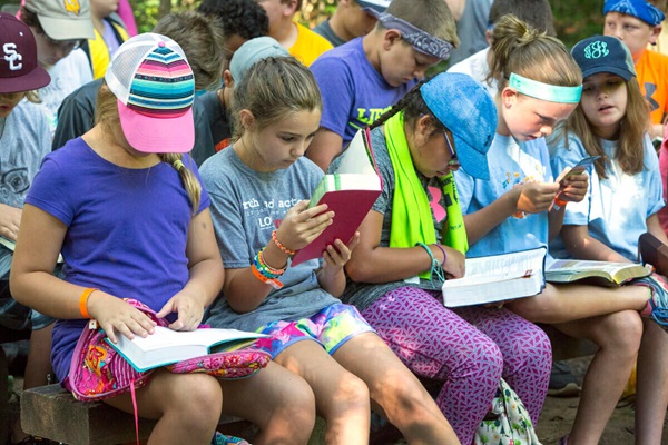 Les campeurs d'été Wesley Hendricks, Reid Lemmon et Wesson Parker cherchent un passage de la Bible pendant le culte du matin au camp Cedar Crest à Lyles, Tennessee. Cedar Crest appartient et est géré par la Conférence annuelle du Tennessee de l'Église méthodiste unie depuis 1959. Photo par Kathleen Barry, United Methodist Communications.