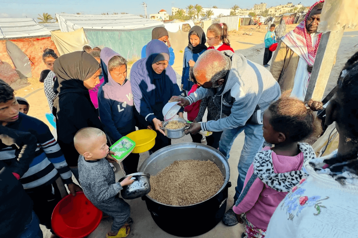Huda's family arrives at the camp gathering point for a hot, cooked meal. Photo courtesy International Orthodox Christian Charities (IOCC).