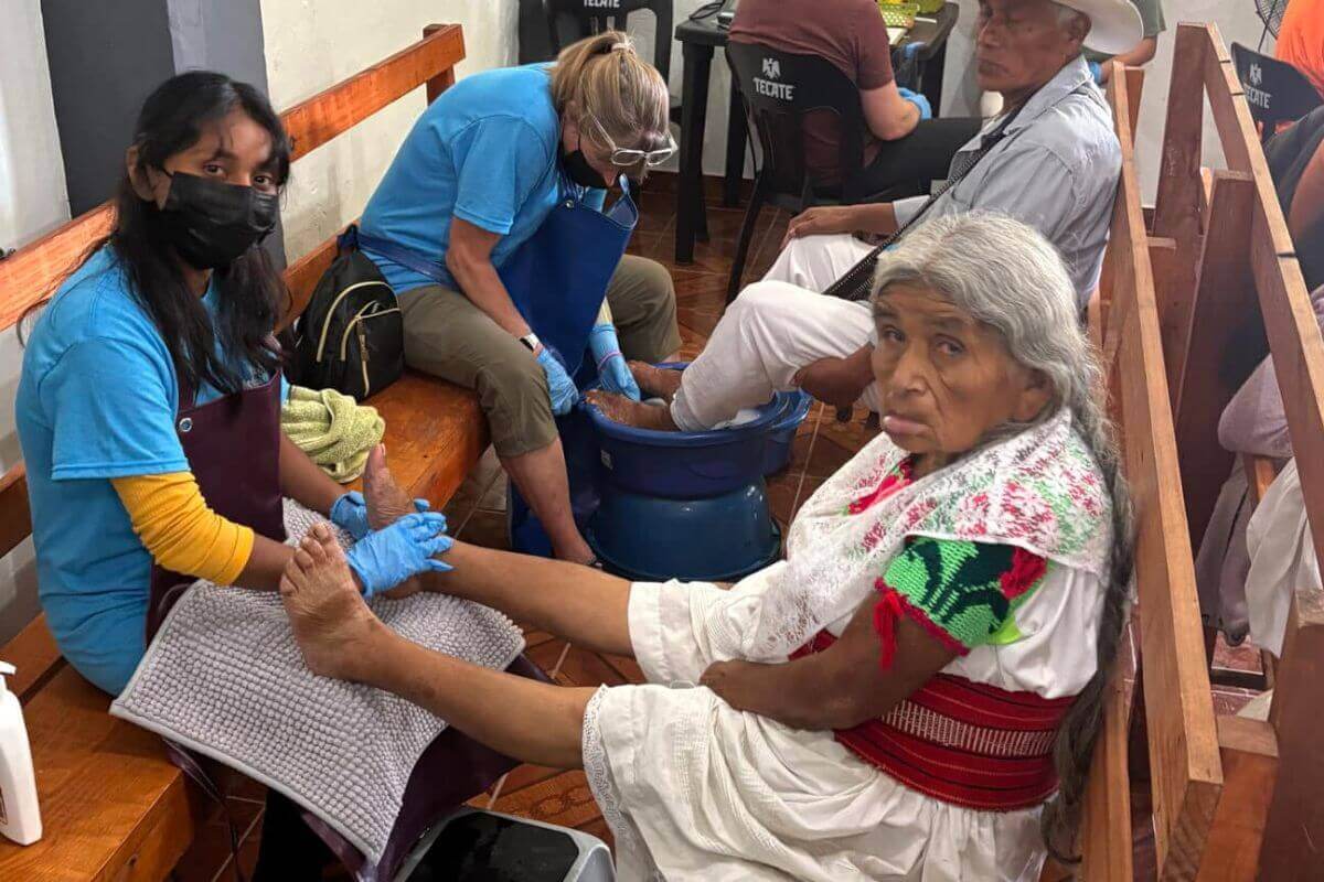 The Wesley Memorial Church volunteer medical team washes the feet of their Totonaco patients in Ixtepec, Mexico. Photo courtesy of Wesley Memorial Church.
