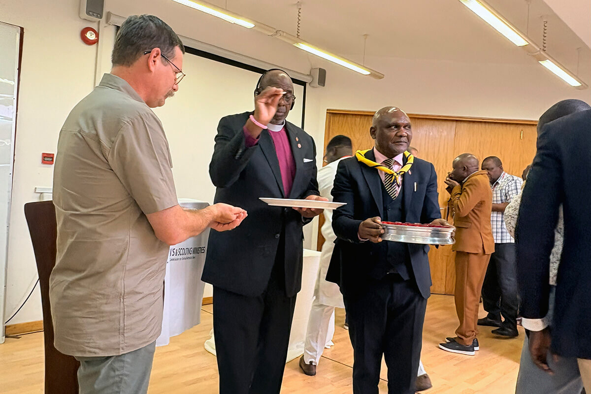 (From left) Steven Scheid, director of the Center for Scouting Ministries for United Methodist Men, receives communion from Bishop L. Jonathan Holston, who leads the North Alabama and Alabama-West Florida conferences, and Bishop Nelson Kalombo Ngoy of the Tanganyika Episcopal Area. The communion service was part of a meeting held Dec. 9-11 by the Commission on United Methodist Men at Africa University in Mutare, Zimbabwe. About 30 men gathered to discuss how to grow men’s ministry on the continent. Photo by Eveline Chikwanah, UM News.