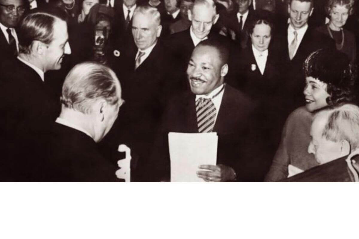 Rev. Dr. Martin Luther King, Jr., winner of the 1964 Nobel Peace Prize, being congratulated by His Royal Highness Crown Prince Harold (left) and His Majesty King Olav V (back to the camera) in Oslo, Norway, December 10, 1964. Dr. King is joined by his wife Coretta on his left. photo by Associated Press