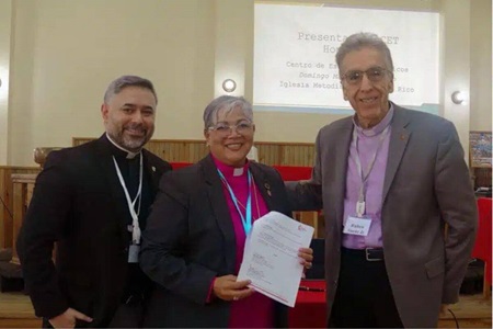 The Rev. Luis Daniel Román, dean of Puerto Rico’s Methodist Center for Theological Studies; Bishop Lizette Gabriel Montalvo, episcopal leader of the Methodist Church of Puerto Rico; and Bishop Rubén Sáenz Jr., episcopal leader of the United Methodist Mission in Honduras and president of the Council of Bishops of The United Methodist Church, display the agreement signed between the two churches to establish a lay formation program. Photo courtesy of Rev. Gustavo Vásquez, UM News.