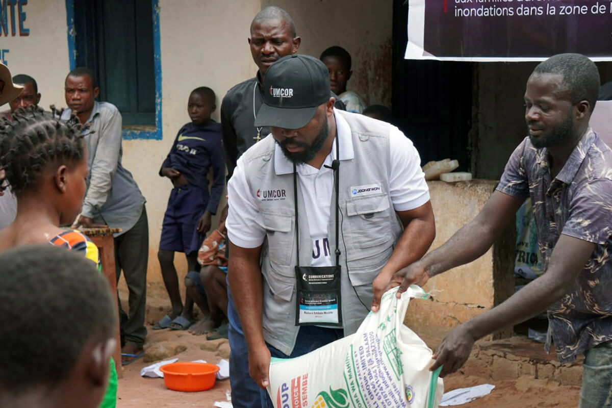 Richard Mushitu, the Tanganyika Episcopal Area’s Disaster Management coordinator, helps distribute bags of flour during an emergency humanitarian aid distribution organized by The United Methodist Church. The project, funded by the United Methodist Committee on Relief and local resources, provided food and essential non-food items to 700 people affected by devastating floods and forced displacement in the Nyunzu and Kalemie territories of Congo. Photo courtesy of the Disaster Management Office of the Tanganyika Episcopal Region.