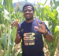 Pastor Collins Prempeh gives the sign for “I love you” as he stands in a field of maize, grown by the Deaf Ministry Farming Project in the Weirmouth area of Mutare, Zimbabwe. Prempeh is the first regional missionary for Deaf and hard-of-hearing ministries in The United Methodist Church’s Zimbabwe East Annual Conference. Photo by Kudzai Chingwe.