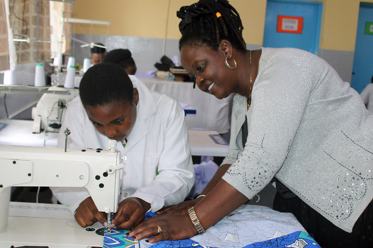 Ruvarashe Chinya, a student at The United Methodist Church’s Murewa High School in Murewa, Zimbabwe, is assisted on an edge-stitching machine by teacher-in-charge Memory Maibheka. The school has launched a uniform factory to help students build skills and to provide financial stability for the school. Photo by Kudzai Chingwe, UM News.
