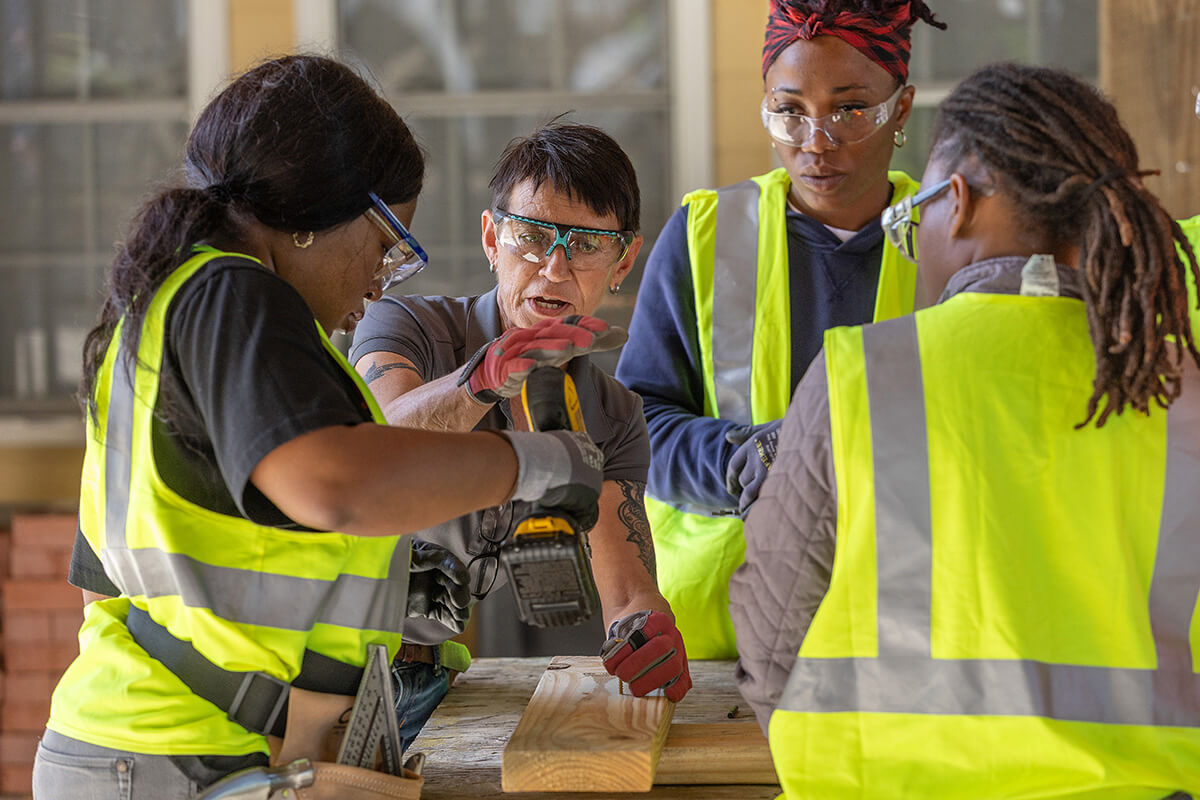 Instructor Marion McAuley (center facing camera) teaches students how to drive screws with an electric drill at the Women in Construction program in Biloxi, Miss. An initiative of  Moore Community House —  a National Mission Institution supported by United Women in Faith — the program prepares women for careers in the skilled trades. Photo by Mike DuBose, UM News.