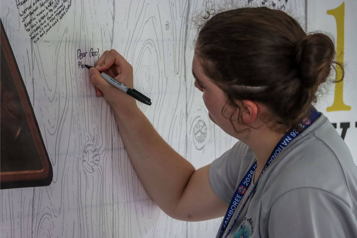 National Jamboree participant writing on the prayer wall. Photo courtesy of Bob Vogt.