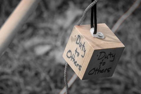 A handwritten pledge on wood: "Duty to Others." Photo courtesy of Bob Vogt.