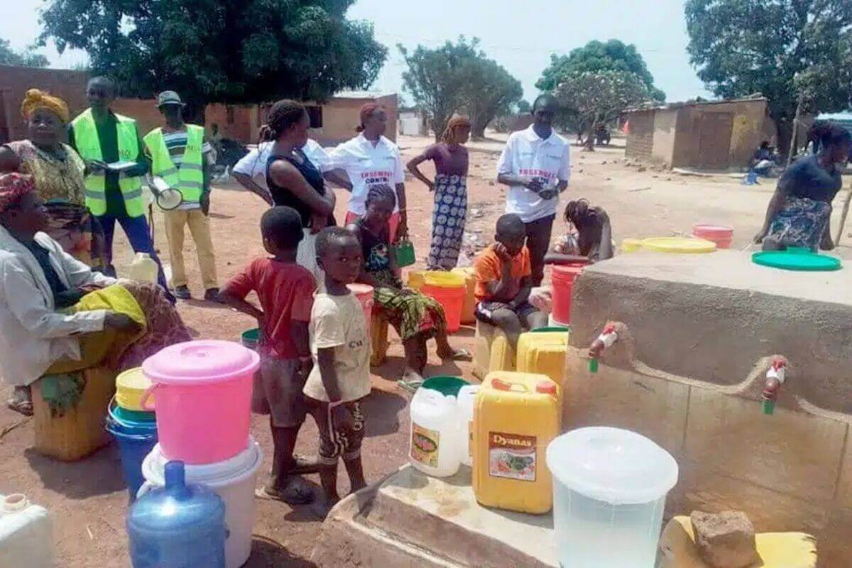 Health workers (in white T-shirts) from the South Congo Health Team visit the newly built water and handwashing station, where they meet and talk with community members about Ebola and its prevention. Photo: South Congo UMC Health Board